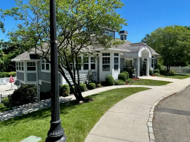 Multi-unit shingle-style building exterior with landscaped walkway